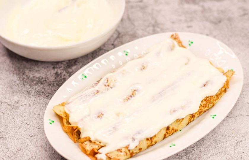 1. Этап. Блины с вишней в сметанном креме: Сметану просто смешайте с сахарной пудрой. Смажьте блины сметанным кремом.