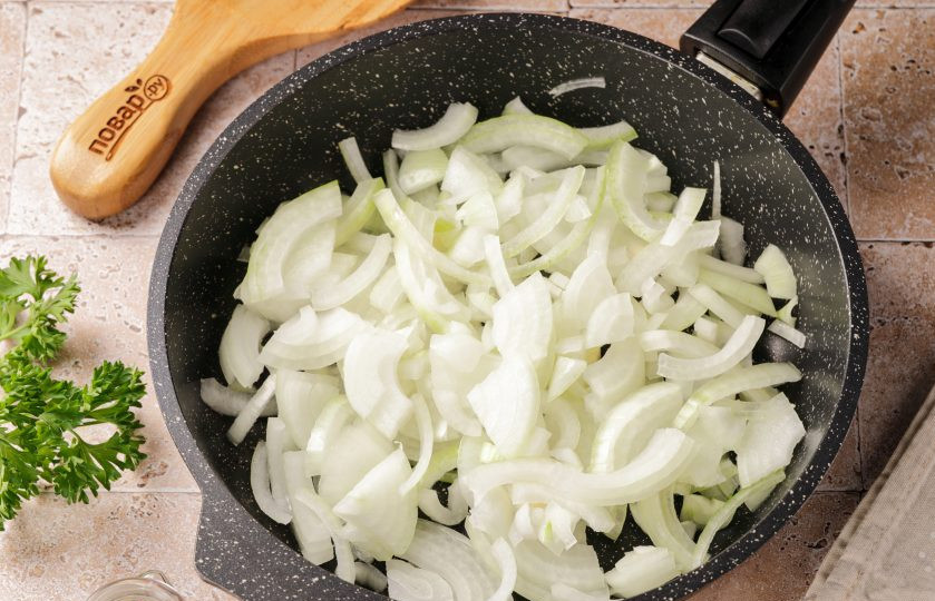 1. Этап. Салат из свиной печени с луком: Лук нарежьте полукольцами или четвертинками. Выложите на разогретую сковороду с маслом.