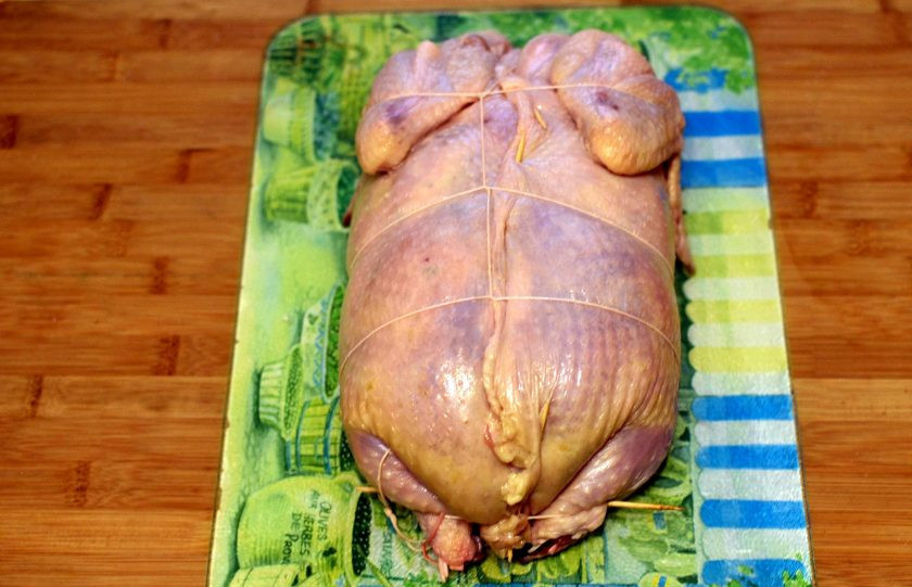 1. Этап. Курица по-царски, фаршированная блинами: Теперь поднимайте края курицы и стягивайте их по разрезу, скрепляя зубочистками. Перевяжите тушку кулинарной нитью на манер колбасы, не слишком затягивая. Руками прижмите тушку, придавая ей форму целой курицы.