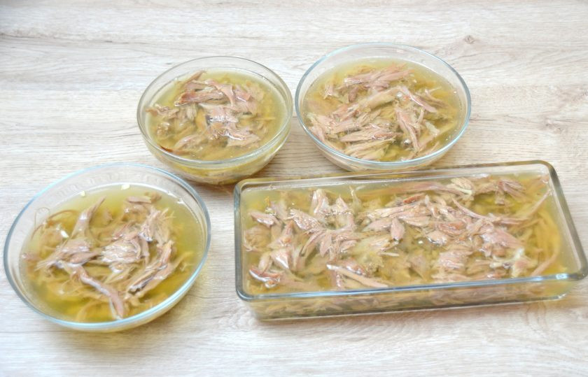1. Этап. Холодец из шеек индейки: Залейте мясо процеженным через сито бульоном. Затяните формочки пищевой пленкой, поставьте в прохладное место для застывания.