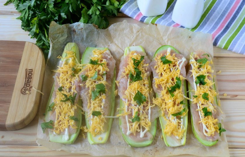 1. Этап. Рулетики из кабачков с куриной грудкой: Сверху выдавите немного чеснока и полейте майонезом. Затем обильно присыпьте натертым на мелкой терке сыром и измельченной зеленью.