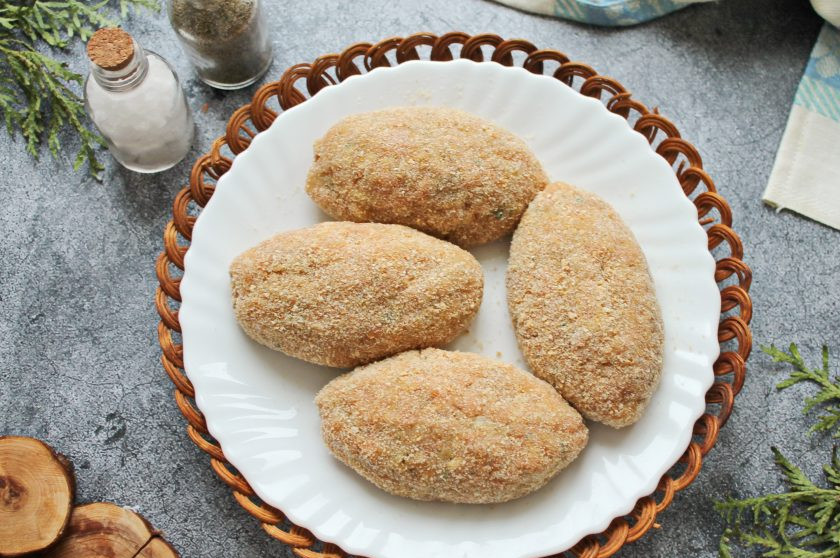 1. Этап. Постные котлеты из горбуши: Влажными руками разделите фарш на четыре части и сформируйте котлеты. Запанируйте их в панировочных сухарях.