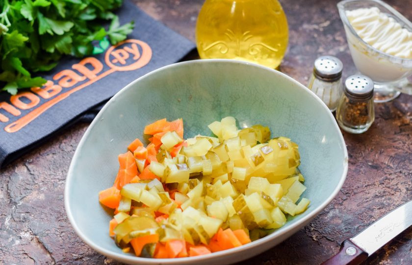 1. Этап. Салат Зимний с шампиньонами: Соленые огурцы нарежьте небольшими кубиками и добавьте в салат.