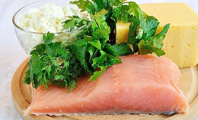 1. Этап. Рулеты с семгой: Сначала сделайте сырную основу. Сыр, порезанный кусочками или натертый, уложите в пищевую плёнку. Опустите его в кипящую воду на 5 минут, чтобы он расплавился.