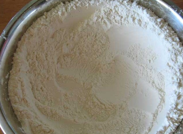 1. Этап. Вареники на кефире: Часть предварительно просеянной муку высыпаем в глубокую сухую миску, делаем в муке углубление.