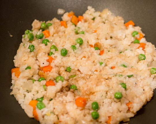 1. Этап. Рис с курицей на сковороде: 6. Добавьте соевый соус, рис в сковороду, залейте бульоном. Пропарьте рис под крышкой 20 минут.