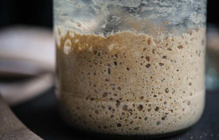 1. Этап. Постный бездрожжевой хлеб: Через 48 часов, когда масса в банке увеличится почти вдвое, а на её поверхности появятся пузырьки, надо добавить туда ещё 100 мл тёплой воды и 50 граммов муки. Закваску нужно аккуратно перемешать и снова закрыть марлей, убрать в тёплое место ещё на 24 часа.