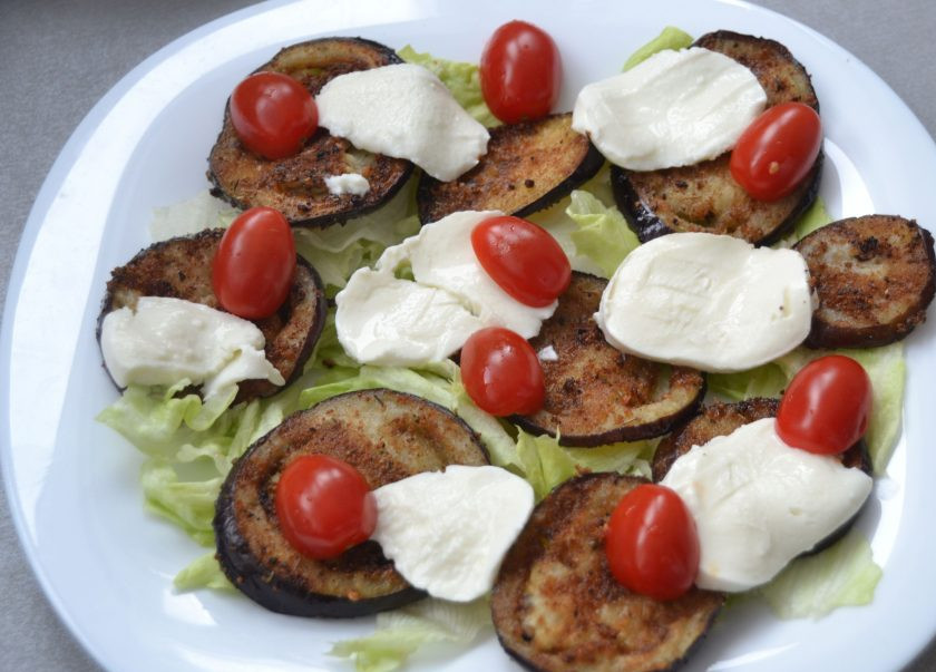 1. Этап. Итальянский салат Пармиджано: Разложите поверх баклажанов ломтики моцареллы и порезанные на половинки или четвертинки помидорки 