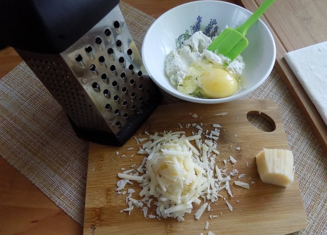 1. Stage. Cheese tart with zucchini: Grate hard cheese on a medium grater. In the cottage cheese beat an egg, add 2/3 of hard grated cheese and combine everything. Leave 1/3 of the hard cheese to sprinkle on the tart before baking.