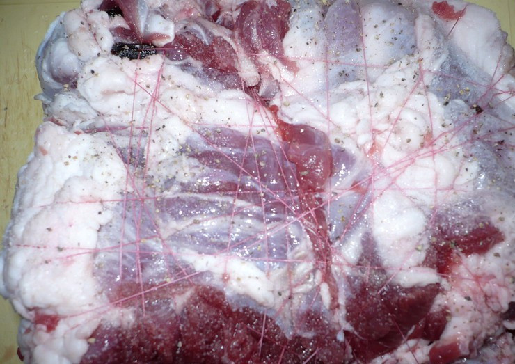 1. Этап. Баранина с черносливом: Теперь сворачиваем баранину плотным рулетом и перевязываем его со всех сторон нитками, с внешней стороны рулет необходимо натереть солью и молотым перцем.