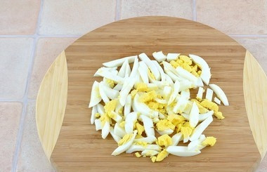 1. Этап. Куриный салат с ветчиной и опятами: В отдельной посуде отварите куриные яйца (вкрутую). Очистите их от скорлупы и нарежьте полосочками.