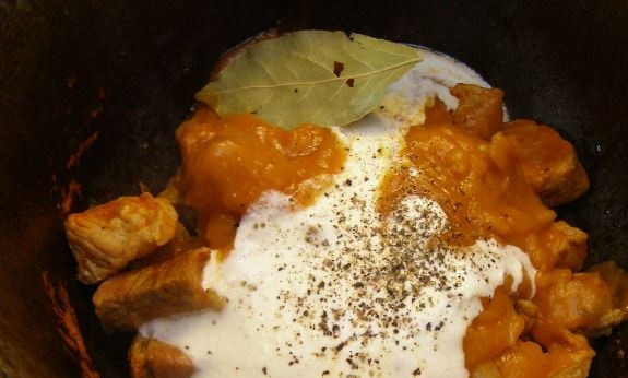 1. Этап. Мясо, тушенное в сметане: К свинине в казанке добавьте обжаренную муку, лук и сметану. Бросьте пару листиков лаврового листа, посолите и поперчите по вкусу. При необходимости, добавьте еще немного воды. Перемешайте все ингредиенты, тушите пять-десять минут до полной готовности.