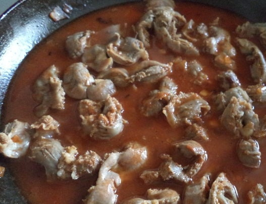 1. Этап. Куриные желудочки с рисом: Добавляем куриные желудочки, солим и перчим по вкусу. Вливаем воду, перемешиваем и тушим все 40-50 минут.