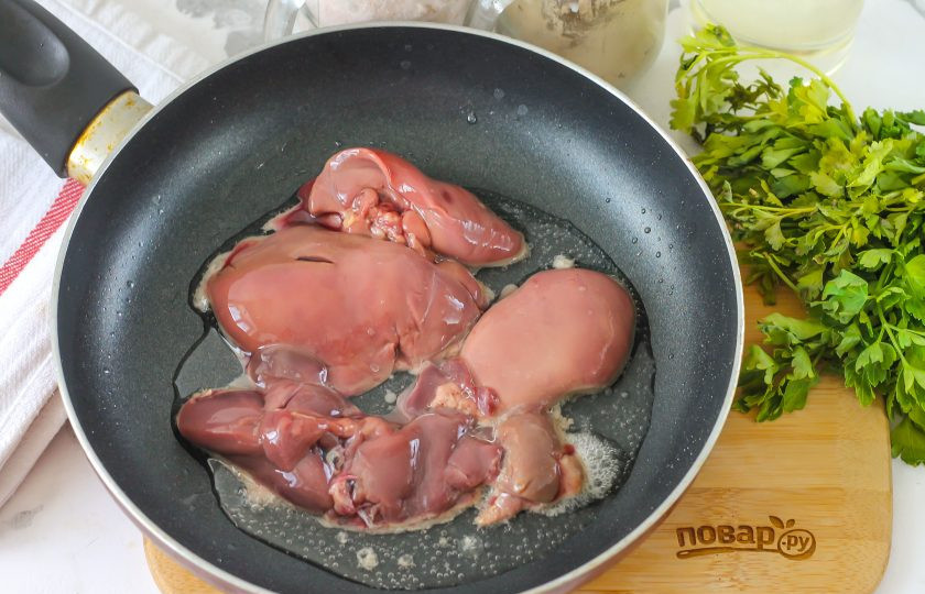 1. Этап. Омлет с печенью: Куриную печень промойте в воде, удалите жилы и пленки, обсушите бумажной салфеткой. Прогрейте в сковороде растительное масло, уменьшите нагрев и выложите в него печень. Обязательно жарьте только на умеренном нагреве, так как при высокой температуре жарки субпродукт начинает 