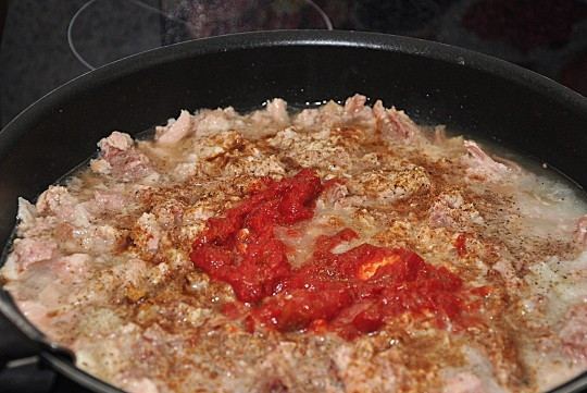 1. Этап. Армейская каша: 4. Тушенку отправляем на сковороду, добавляем к ней выдавленный чеснок и томатную пасту. Жарим, постоянно помешивая, и когда испарится лишняя жидкость, отправляем начинку в жаровню, где варится каша.