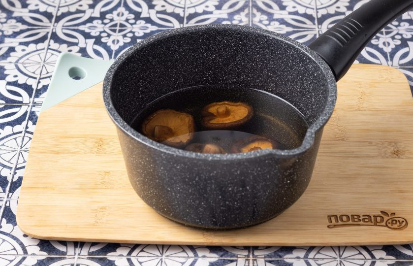 1. Этап. Морская капуста сушеная с кимчи: Сушеные шиитаке залейте водой и отварите в кипящей подсоленной воде 20-25 минут. После откиньте на сито, а бульон сохраните.