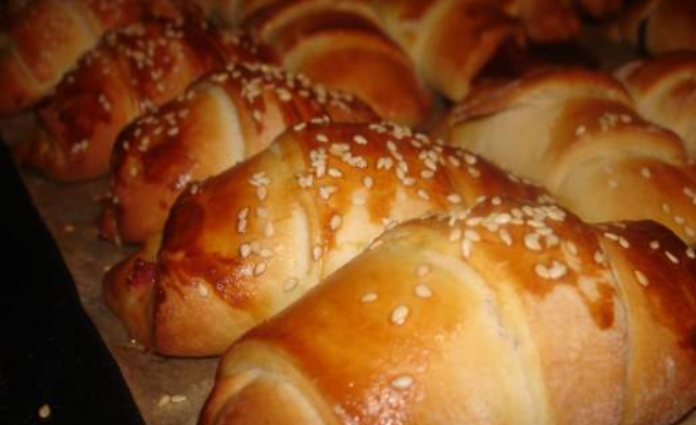 1. Этап. Круассаны без дрожжей: На середину каждого треугольника кладем 1 ч.л. сливочного масла, смешанного с сахаром. Сворачиваем тесто рогаликом (от узкого края — к широкому), формируя круассаны. Перекладываем их на противень, застеленный бумагой для выпечки. Каждый круассан смазываем желтком и посыпаем кунжутом. Выпекаем в духовке до румяности (примерно 25 минут). Приятного аппетита!