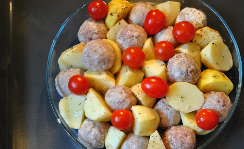 1. Этап. Запеченный картофель с фрикадельками: Выложите фрикадельки и помидоры к картофелю. Уберите запекаться ингредиенты в духовку на 10 минут при 180 градусах.