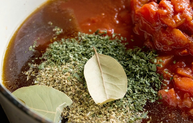 1. Этап. Гуляш из говядины с сыром: 2. Также всыпьте орегано, нарезанную петрушку, помидоры кубиками и лавровый лист. Доведите ингредиенты до кипения, а потом варите 15 минут.