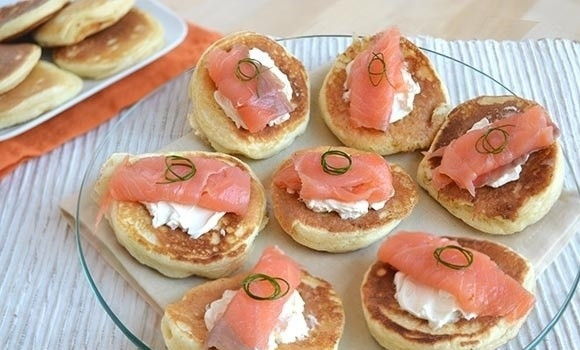 1. Этап. Вкусные оладушки: Затем положите кусочек копченого лосося, украсьте перьями зеленого лука и подавайте на стол.