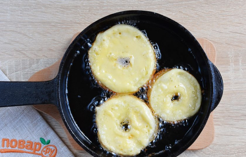 1. Этап. Яблочные пончики: Сразу кладите яблочные колечки в горячее масло. Учитывайте, что пончики немного подрастут, чтобы они не слиплись, нужно соблюдать дистанцию между ними. Когда я фотографировала, они уже успели подрасти и подрумянится с нижней стороны.