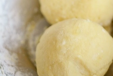 1. Этап. Именинный пирог: Замесите гладкое песочное тесто. Оберните его в пищевую пленку и поставьте в холодильник на час. Разделите тесто на две части.