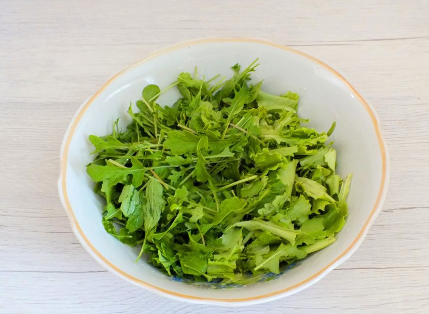 1. Этап. Салат с крабовыми палочками и рукколой: Рукколу и салатный лист вымойте, стряхните воду, выложите в просторный салатник.