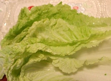 1. Этап. Салат с копченой курицей и кукурузой: Пекинскую капусту ополаскиваем. Снимаем листы один за другим. Нижнюю часть листа с твердым основанием отрезаем от верхней, деля лист напополам. Плотную часть мелко нарезаем, а верхняя нам еще пригодится.