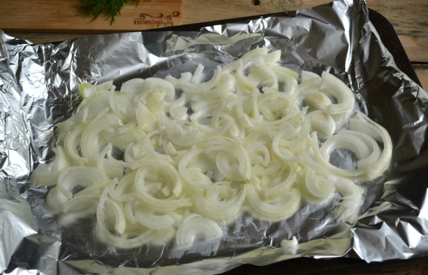1. Этап. Пангасиус в духовке под сыром: Противень застелите фольгой или пергаментом, выложите лук довольно толстым слоем.