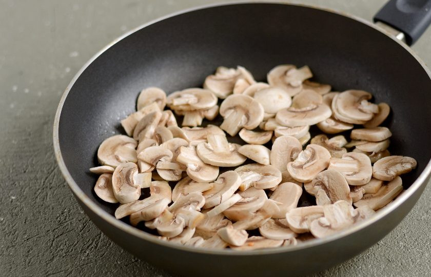 1. Этап. Макароны с капустой: Нарежьте шампиньоны пластинами. Затем обжарьте их на среднем огне до испарения жидкости.