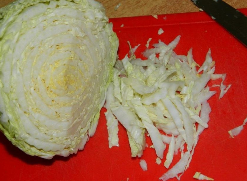 1. Этап. Кукурузный салат с помидорами и капустой: Нашинкуйте пекинскую капусту и выложите в салатник.