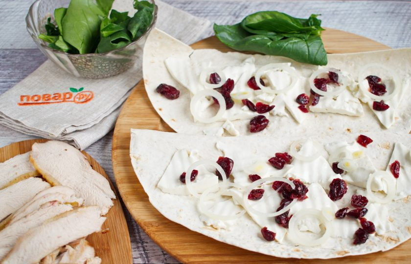1. Этап. Кебаб (шаурма) из индейки с клюквой: Круглый лаваш разрежьте на 2 половинки. На каждую выложите брынзу, нарезанную тонкими ломтиками, вяленую клюкву, кольца лука.