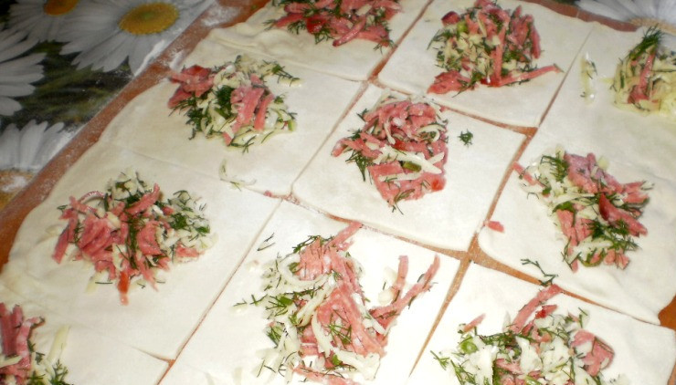 1. Этап. Пирожки с колбасой и сыром: В серединку каждого квадрата кладем небольшое количество начинки.