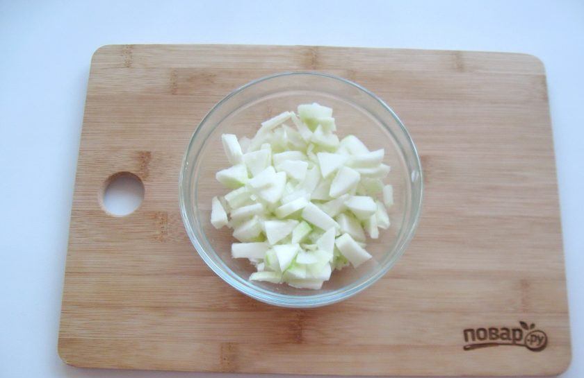 1. Этап. Салат Мошенница: Одно небольшое яблоко помойте, очистите, удалите сердцевину и мелко нарежьте. Половину луковицы нарежьте мелкими кубиками, добавьте к яблоку.