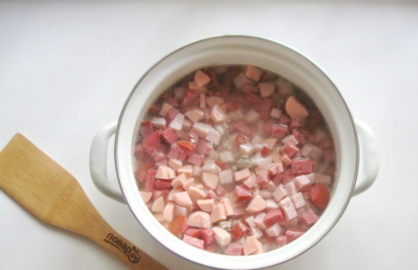 1. Этап. Солянка Ростовская: Нарезанную колбасу, желудки и курицу выложите в кастрюлю с картофелем и бульоном.
