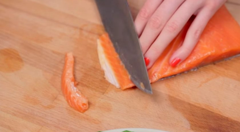 1. Этап. Сэндвич-торт Джейк из Время приключений: 1. Для начала подготовьте начинку. Для этого нарежьте тонкими пластинками огурец и тонкими полосками рыбу. Затем слегка измельчите руками листья салата и укроп.