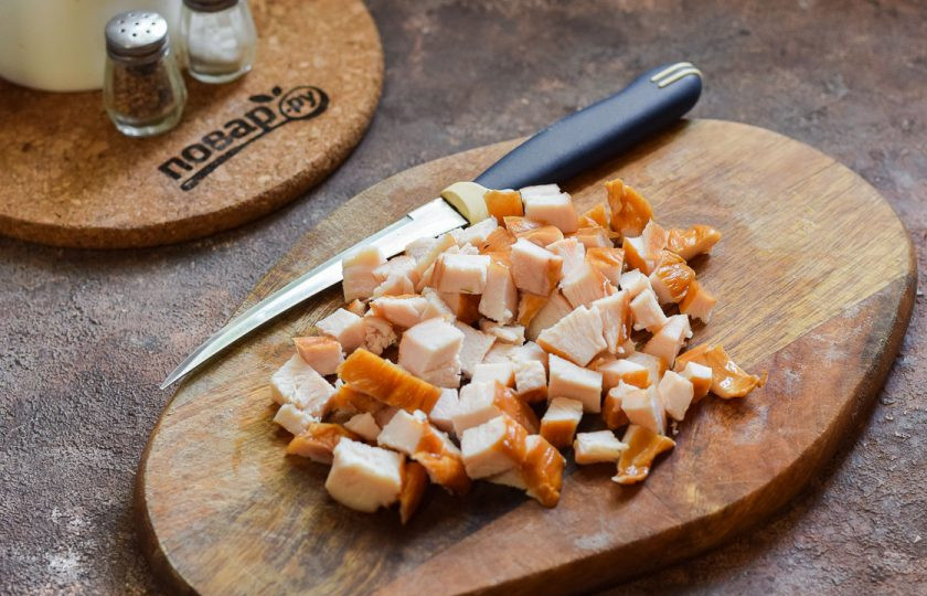 1. Этап. Салат с копченой курицей и огурцом: Копченую куриную грудку нарежьте небольшими по размеру кубиками.