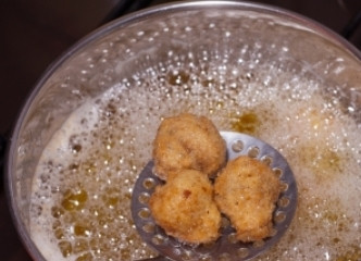 1. Этап. Шампиньоны в кляре: Опустите грибы в кипящее масло и обжарьте до золотистой корочки.