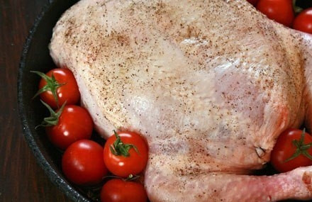 1. Этап. Новогодняя курочка без костей, фаршированная по-тоскански: В форму для запекания влейте оливковое масло. Швом вниз уложите курицу. Посыпьте её шалфеем. Рядом уложите промытые помидорки.