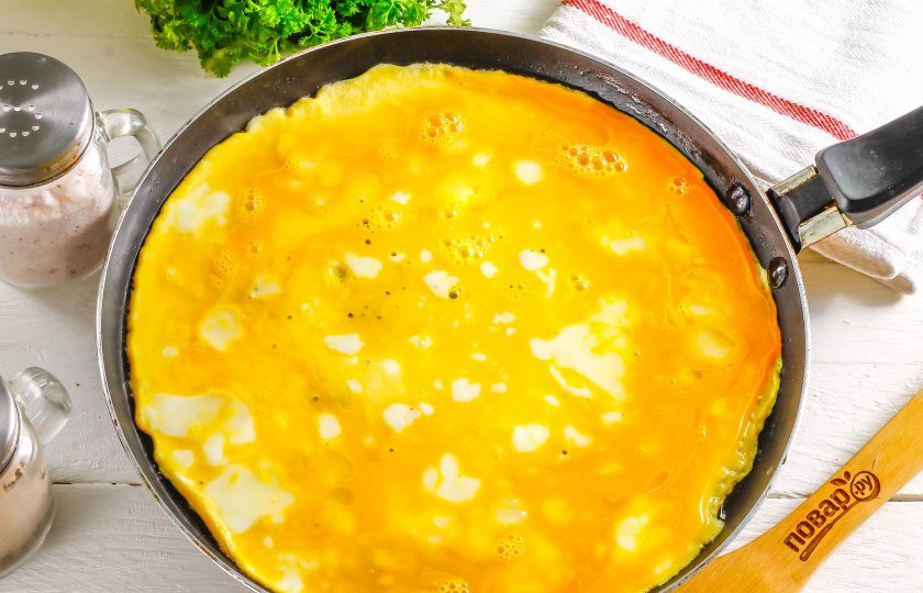 1. Этап. Рулет на год Крысы: Прогрейте на сковороде растительное масло и влейте яичную смесь. Обжарьте омлет с обеих сторон по 1-2 минуте.