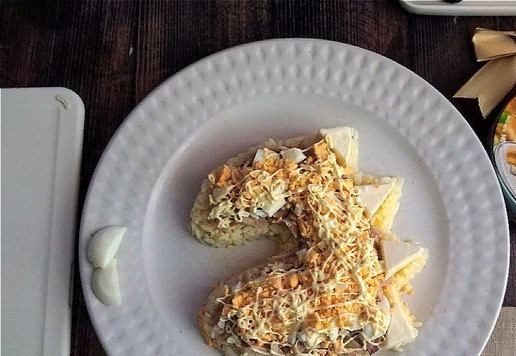 1. Этап. Салат Новогодний Дракончик: Третий слой - мелко порубленное яйцо. Отрежьте от него немного белка. Он нам пригодится для формирования глазок. Укладываем аккуратно порубленное яйцо на курино-сырный слой и поверх - майонезную сетку.