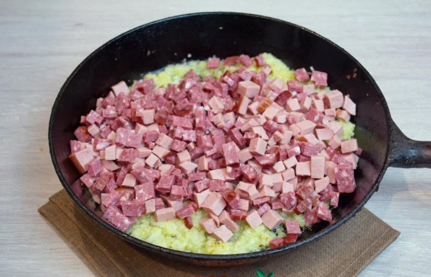 1. Этап. Солянка сборная мясная: 4. На растительном масле обжарьте измельченный лук. Мои домашние не любят крупные кусочки лука в солянке. Я прилавчилась измельчать лук не ножом, а блендером. Так фрагменты лука получаются меньше и однороднее. Когда лук обжарится, добавьте колбасные изделия и обжарьте все вместе.