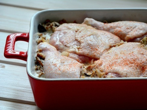 1. Этап. Гречка с курицей: Окорочка курочки тщательно вымойте, удалите остатки перьев, если такие имеются. Обсушите мясо и натрите смесью из соли и сладкой молотой паприки. Выложите окорочка на гречку, немного их туда вдавите.