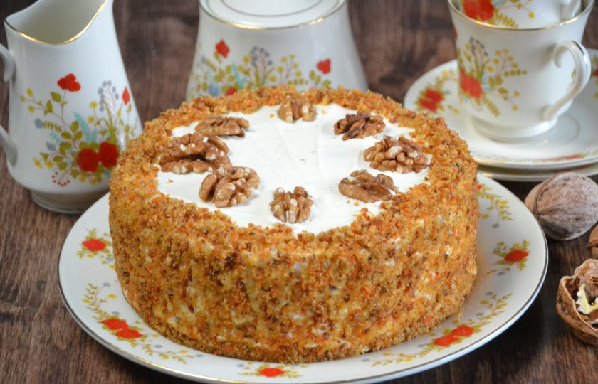 1. Этап. Морковный торт с вишней: Посыпьте крошкой бока торта, украсьте половинками ядер грецких орехов.