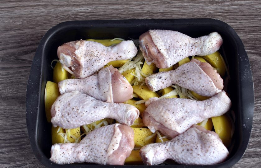 1. Этап. Куриные ножки с картошкой и грибами: Куриные голени промойте, обсушите. Выложите поверх картофеля, посолите и поперчите. Поставьте в духовку, разогретую до 200 градусов до образования легкой корочки.