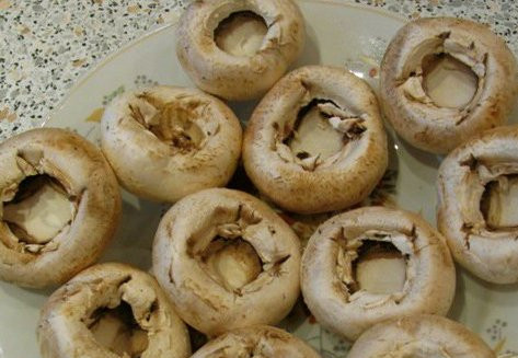 1. Этап. Фаршированные грибы в мультиварке: Первым делом нам нужно промыть хорошенько грибы и аккуратно при помощи чайной ложки отделить ножки грибов от шляпок.