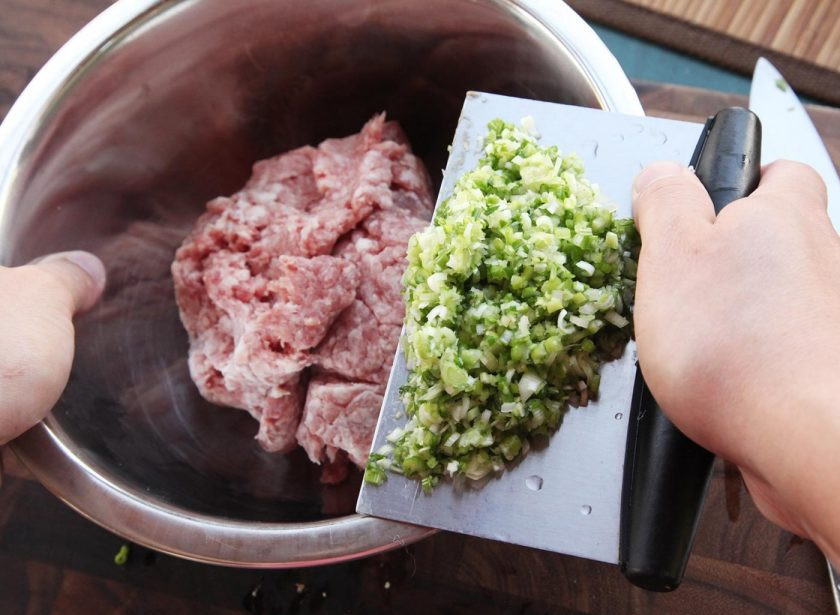 1. Этап. Японские пельмени Гедза со свининой: 5. В фарш добавьте капусту, имбирь, чеснок, измельченную зелень, соль, сахар и перец по вкусу. Все как следует перемешайте.