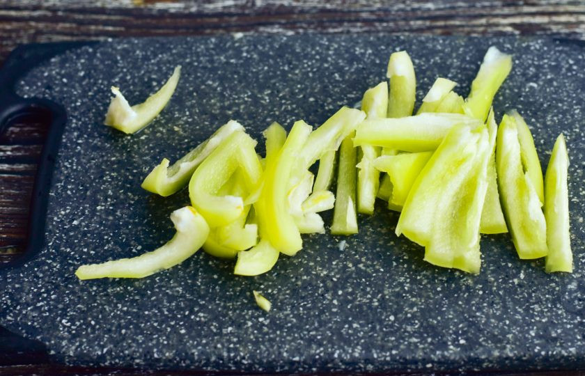 1. Этап. Салат с курицей по-китайски: Болгарский перец вымойте, удалите серединку и нарежьте полосочками.