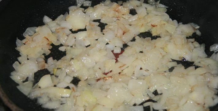 1. Этап. Салат из кальмаров и шампиньонов: 4. Лук очищаем и нарезаем мелким кубиком. На раскаленной сковороде обжариваем луковицу до золотистого цвета.