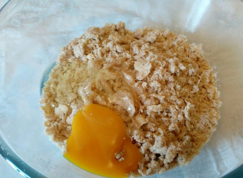 1. Этап. Квише с овощной начинкой: Добавьте в получившуюся крошку одно яйцо и замесите мягкое тесто, легко отстающее от стенок миски.